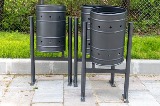 A shot of three garbage bins placed in the park