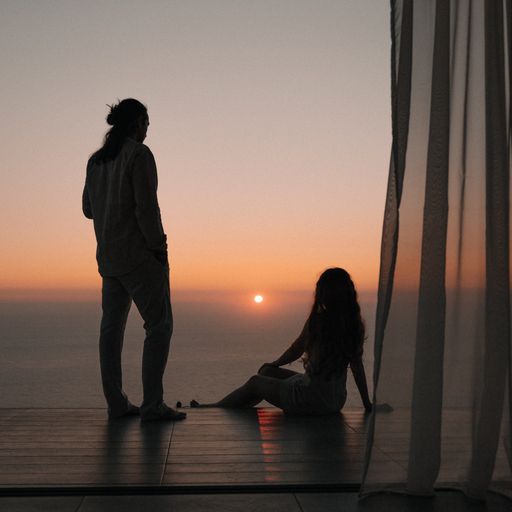 A silhouette of a young couple enjoying the beautiful sunset view on the seashore