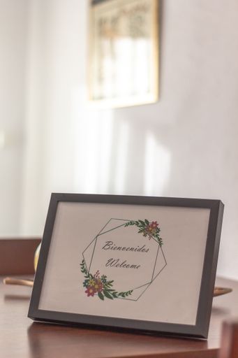 A vertical shot of a welcome card in a frame on a table