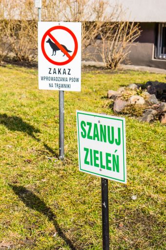 A polish warning signs on the green grass on a sunny day