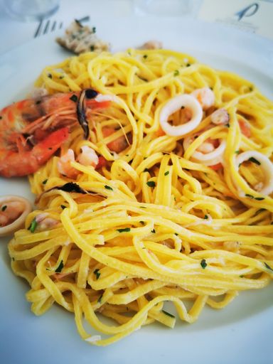 А delicious dish made of spaghetti with shrimps on a white plate