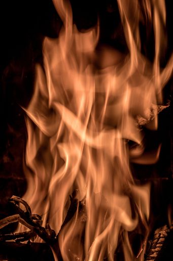 A vertical closeup shot of a bonfire with a dark background