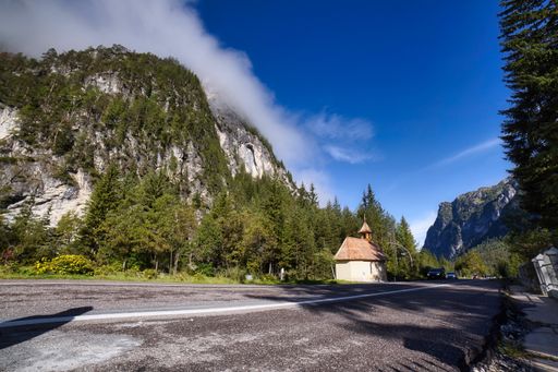 A horizontal shot of beautiful scenery of the Dolomites and a chapel in the middle, Italy