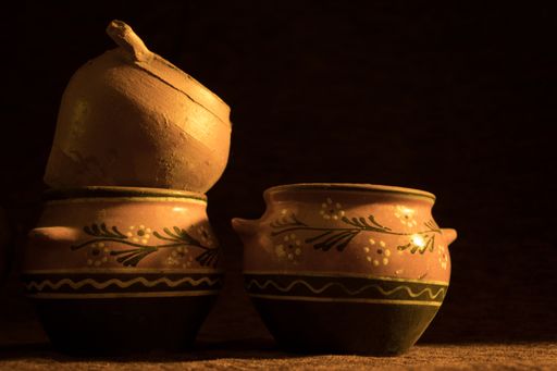 A panoramic closeup shot of ceramic painted vases on a dark background