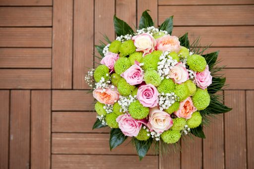 A top view shot of a flower bouquet on a wooden tabl