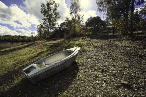 A beautiful scene of a  boat in the middle of the field combined with cloudy sky view