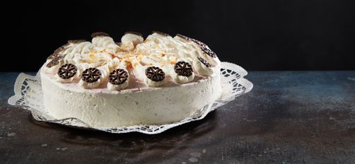 A Delicious white strawberry cake garnished with chocolate decoration served on a table