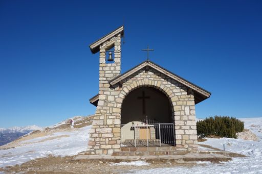 A chapel on a snowy top of a lofty mountain