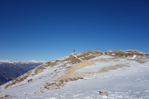 A slope of a bare mountain with a snowy top in the morning