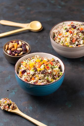 A vertical shot of bowls with quinoa salads and nuts