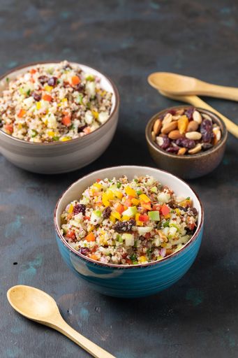 A vertical shot of bowls with quinoa salads and nuts