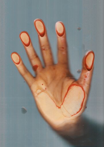 A vertical shot of a female's hand pressing on a foggy window