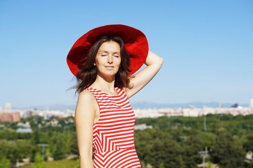 A Spanish woman wearing a red hat and posing