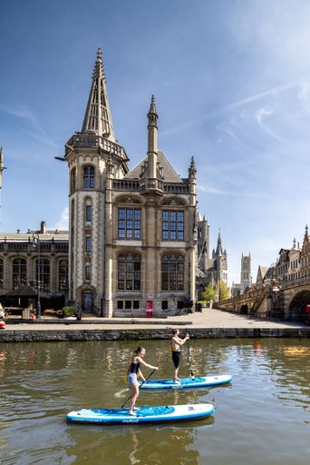 Aerial view of Bruges, featuring the historic Saint Salvator's Cathedral amidst a cityscape under a clear blue sky.