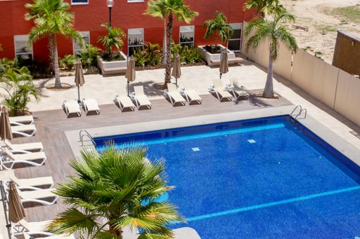 A beautiful view of a swimming pool and a patio from the house balcony