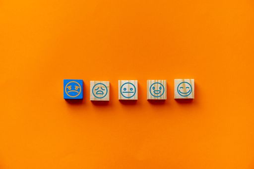 An orange background with emotion tiles to select for customer satisfaction survey
