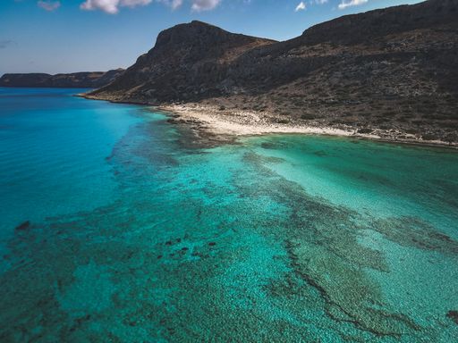An aerial view of the beautiful seascape and rocky cliffs under the blue clear sky