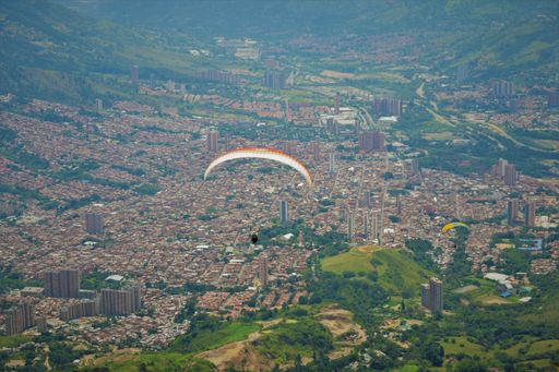 A  skydiver flying her parachute over a city
