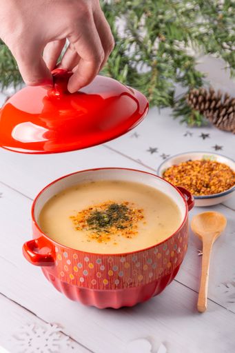 A vertical shot of a pot of pumpkin cheese soup