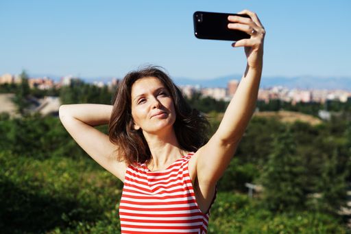 A young Caucasian female in a striped dress taking a selfie in Madrid, Spain