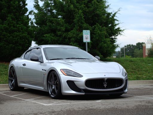 A horizontal shot of Maserati granturismo sports car parked near a vegetated area. Kanas city, US