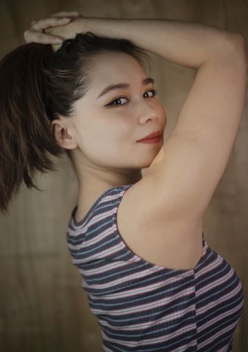 A portrait of a Vietnamese female glancing over the shoulder.