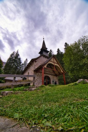 A vertical shot of Chapel of "Lago di Braies" Prags, Italy under a blue cloudy sky