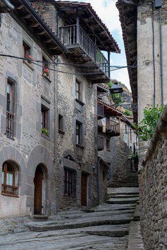 A vertical shot of an alleyway with stone house in a town in Spain