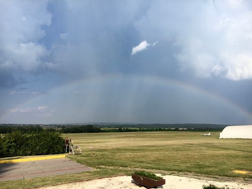 A rainbow in the gloomy sky over a countryside landscape