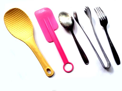 A white surface with kitchen utensils equipment - spoons and forks