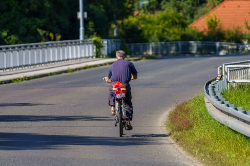 A back view of a senior man riding a bicycle