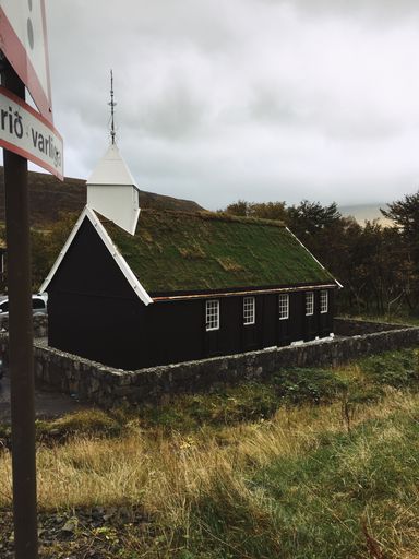 A scenic view of an old church in the Faroe Islands, Denmark under a gloomy sky