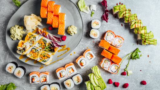A top view of appetizing sushi assortment on the plate and a gray surface