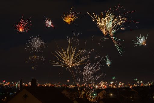 Colorful fireworks in the dark sky at new year over a village
