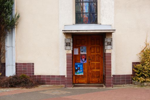 An old wooden entrance door to a church in the Stare Zegrze district during the daytime