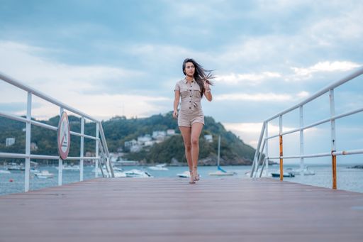 An attractive female walking on a pier by the beautiful ocean captured in San Sebastian, Spain
