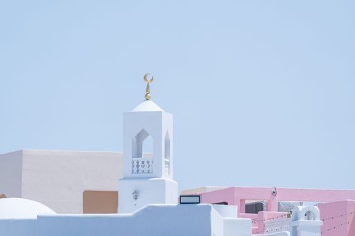 Minimalist mosque with crescent moon against clear blue sky in Doha