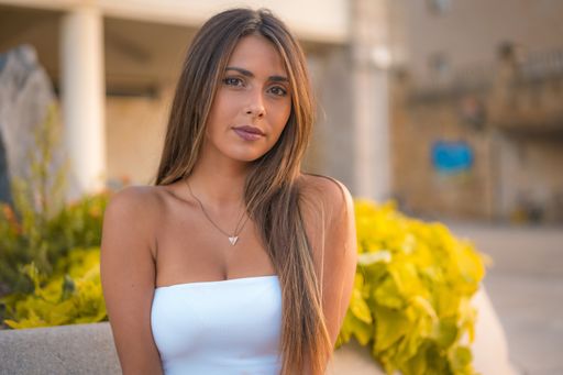 A young beautiful brunette woman posing near the sea during the sunset in San Sebastian, Spain