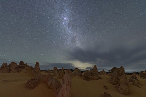 Stunning night sky over Pinnacles Desert, Western Australia, with starry sky and unique limestone formations.