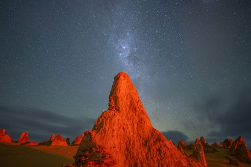 Stunning view of Pinnacles Desert at night under a starry sky, featuring unique limestone formations in Western Australia.