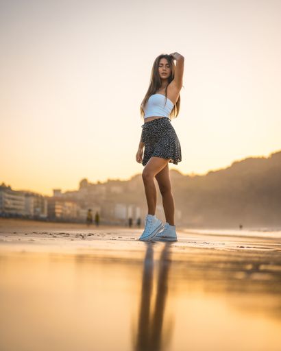 A vertical shot of an attractive female standing on the beach captured in Zarautz, Spain