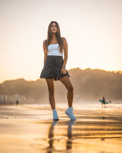 A vertical shot of an attractive brunette woman in the sandy beach in Zarautz, Spain