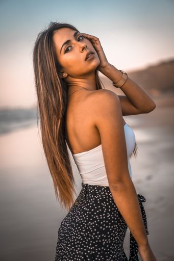 A young beautiful brunette woman posing near the sea during the sunset in San Sebastian, Spain