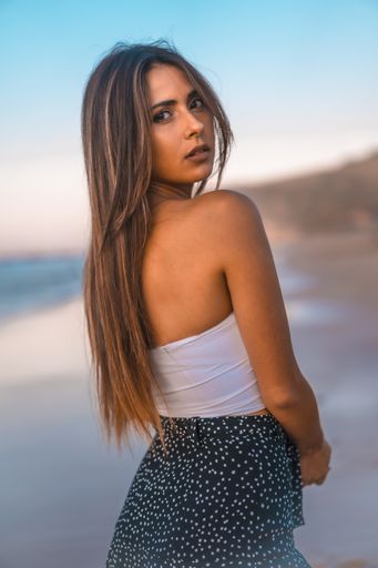A vertical shot of an attractive female standing on the beach captured in Zarautz, Spain