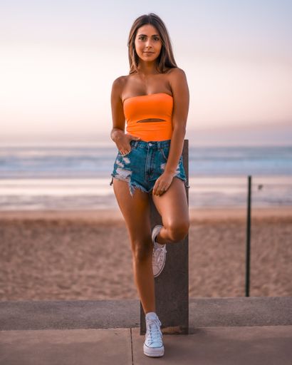 A vertical shot of an attractive brunette posing at the beach in Zarautz, Spain