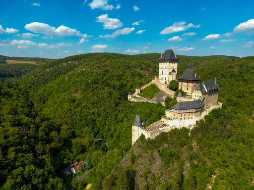 Aerial view of Karlstejn Castle in Czech Republic surrounded by lush green forests