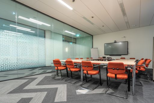 The conference room interior of a modern office with white walls and a monitor