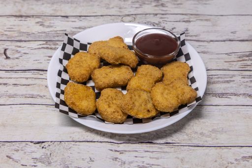 A closeup shot of deep-fired chicken nuggets with barbecue sauce
