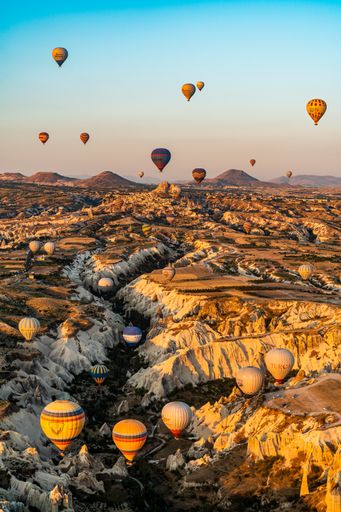 A vertical shot of colorful hot air balloons flying over Cappadocia, Turkey.