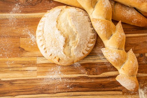 A top-view of freshly baked loaves of bread on a rustic wooden table